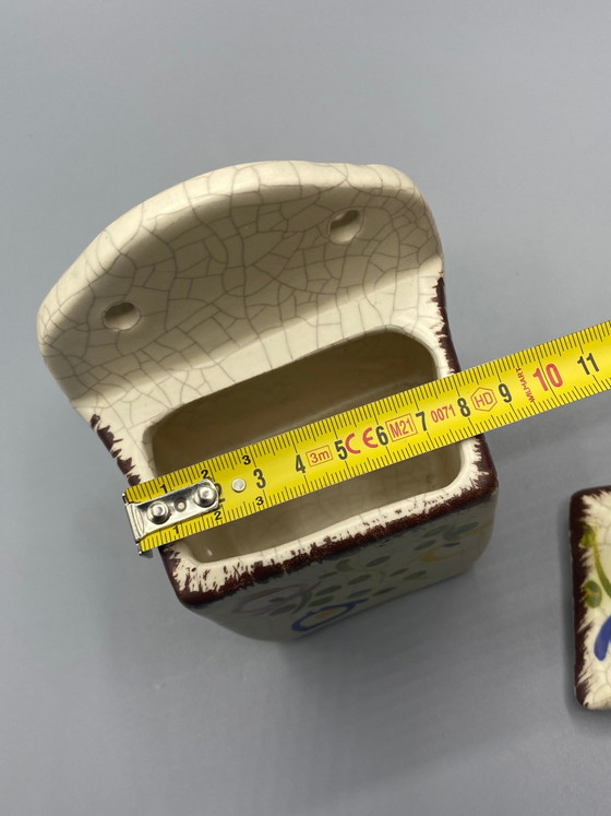 Wandgemonteerde keramische zoutpot met gebarsten emaille en veelkleurige bloemversiering – Frankrijk, circa (photo 6 of 8)