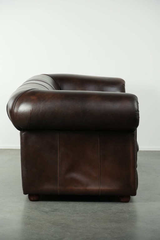 Lussuoso divano Chesterfield in morbida pelle bovina marrone, dal look inglese senza tempo.