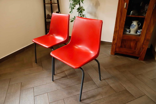 Paar rote Kunststoffstühle mit Metallgestell