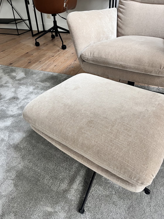 Image 1 of Amy est assise dans un fauteuil avec un repose-pieds.