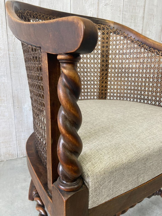 Image 1 of Poltrona antica con intreccio in vimini e decorazioni in legno.