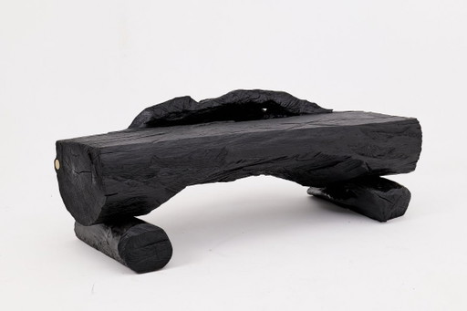 Bank van massief verkoold hout van Logniture – een organisch, modern en sculpturaal zitmeubel.