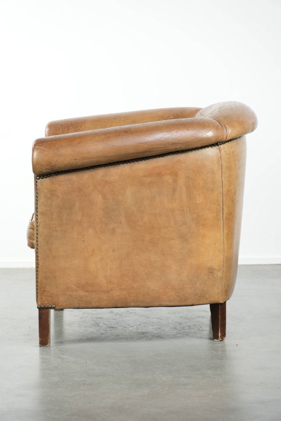 Image 1 of Vintage sheepskin club armchair with beautiful colors and finished with decorative nails.
