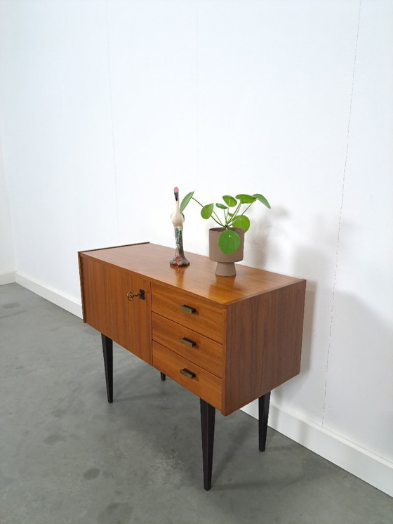 Image 1 of Mid-Century teak kastje op hoge zwarte poten met lades