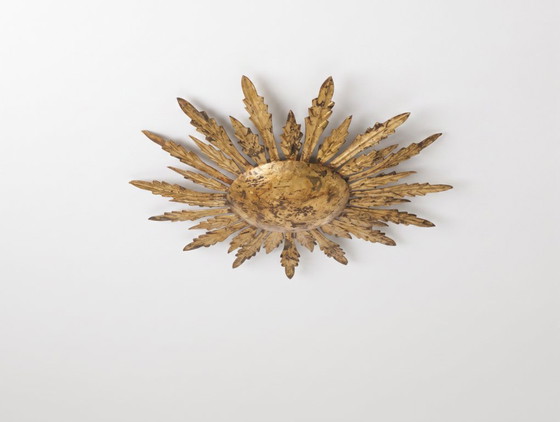 Plafondlamp met verguld metalen ontwerp in de vorm van een zonnestraal met bladmotieven, uit het midden van (photo 9 of 9)
