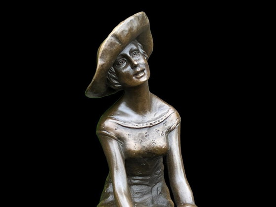 Image 1 of Statua in bronzo di una donna su una sedia