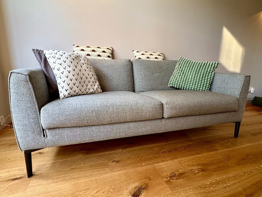 Comfortabele 2,5 zits bank met bijpassende poef – grijs gemêleerd