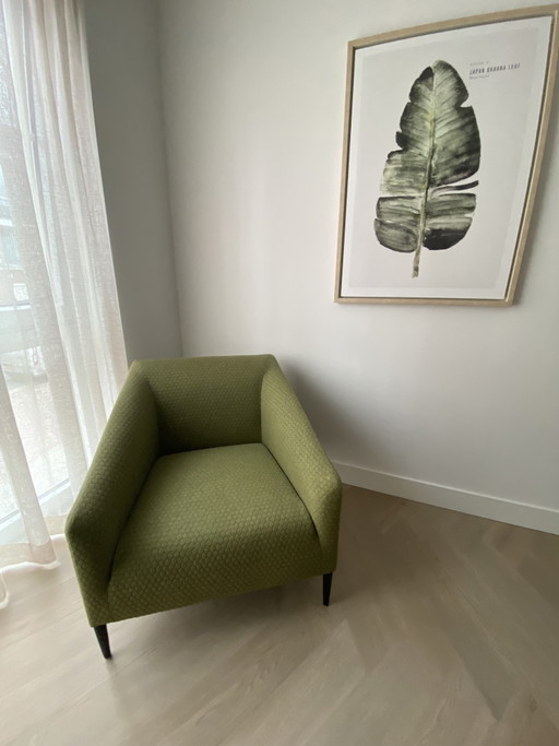Sijben armchair in moss green fabric with matte black steel legs.