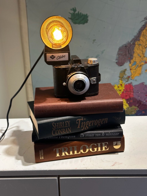 Lampe de table unique en forme de caméra sur une pile de livres