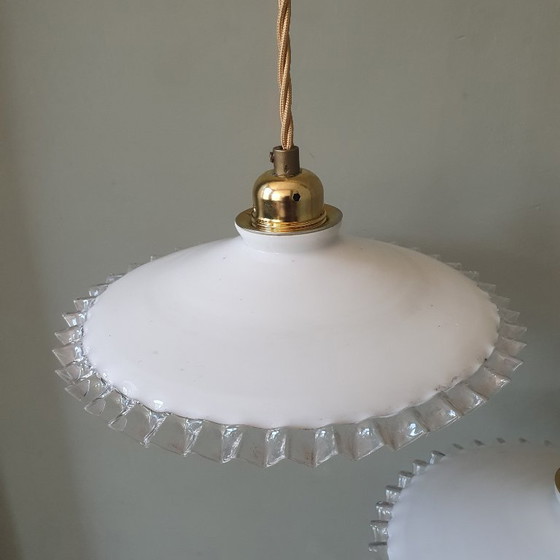 Image 1 of 2 vintage hanglampen van wit opaline glas met een transparante sierrand.