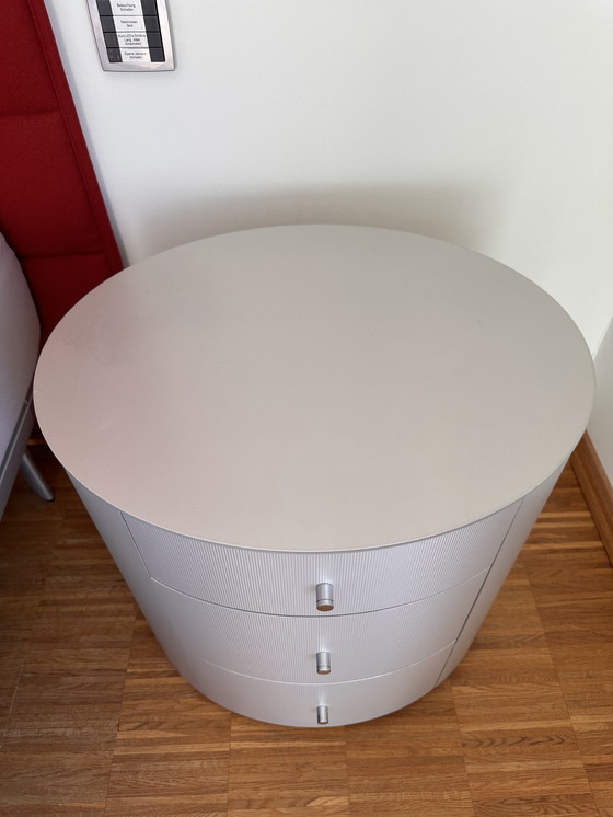 Image 1 of Comodino ovale in legno massello con rivestimento in alluminio spazzolato opaco