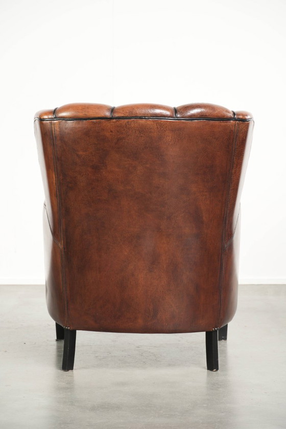 Fauteuil unique en peau de mouton aux couleurs chaudes et profondes, orné d'un passepoil noir. – Leather (photo 4 of 14)