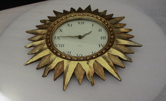 Image 1 of Karlsson Zonneklok vergulde 22k goud zware wandklok uit eind 20e eeuw werkt prima.