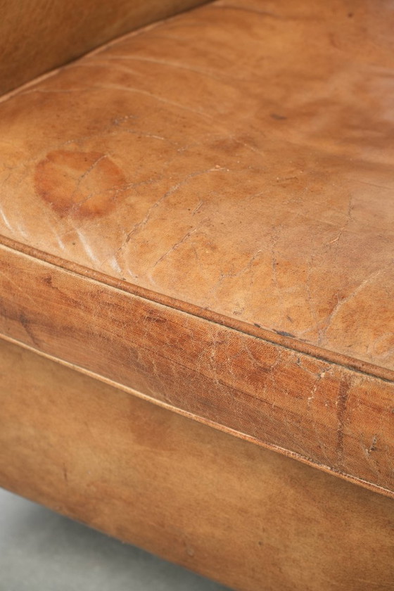 Image 1 of Vintage sheepskin club armchair with beautiful colors and finished with decorative nails.