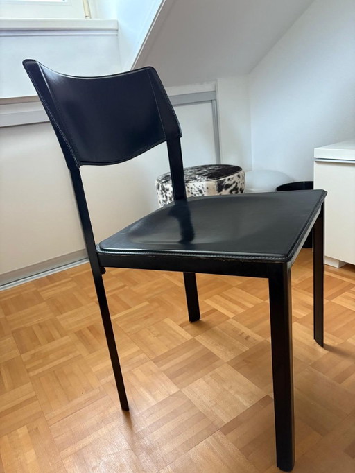 6 (eventueel 8) onverwoestbare Italiaans design eetkamerstoelen, zwart tuigleer, stalen constructie. Afmetingen: hoog 82, zittin