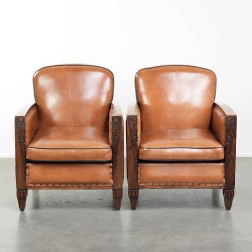 2 x Prachtige schapenleren Art Deco fauteuil met mooi houtsnijwerk en zwarte biezen