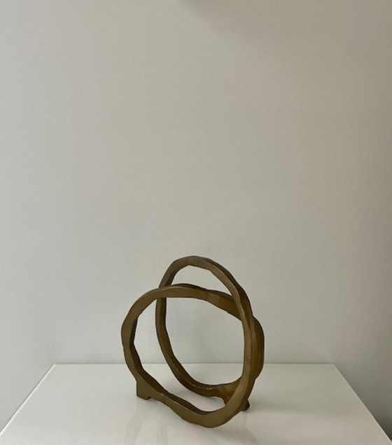 Image 1 of Escultura de diseño con forma de anillo abierto en oro mate.