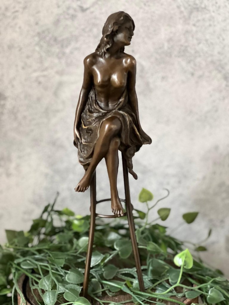 Statua di bronzo di donna su sedia