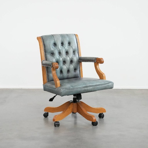 Fauteuil de bureau Chesterfield classique anglais à roulettes, en cuir de vachette bleu clair et bois. Monté sur roulettes.