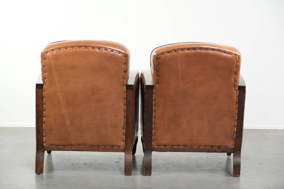 Image 1 of 2 x Prachtige schapenleren Art Deco fauteuil met mooi houtsnijwerk en zwarte biezen
