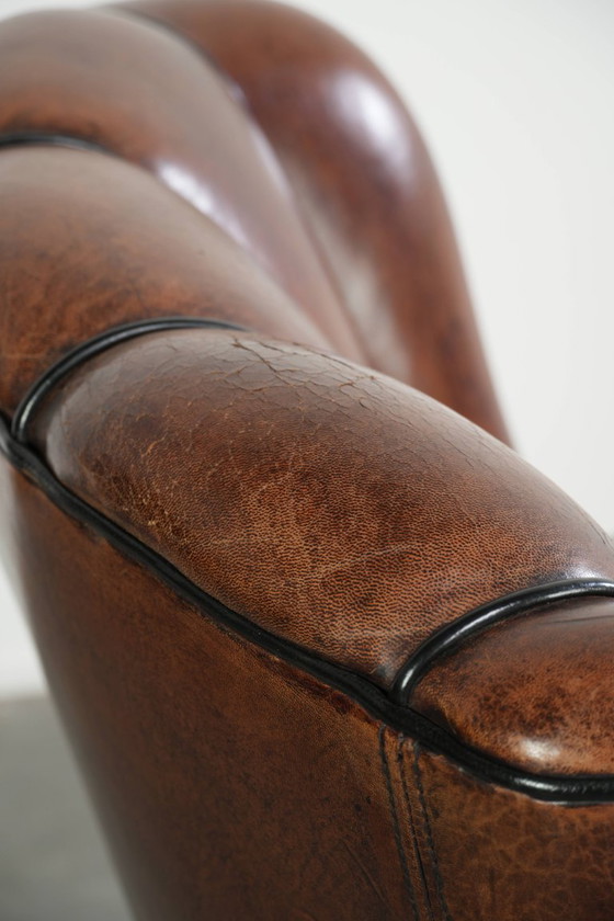 Fauteuil unique en peau de mouton aux couleurs chaudes et profondes, orné d'un passepoil noir. – Leather (photo 14 of 14)