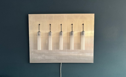 Modern wall lamp with 5 cylindrical glass shades on a metal/stainless steel back plate