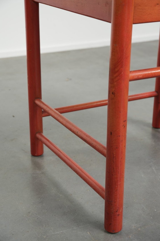 Image 1 of Schöner roter Vintage-Holzstuhl aus den 70er Jahren mit einer Sitzfläche aus geflochtenem Rohrgeflecht.