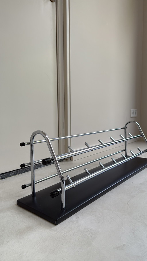 Perchero de pared de los años sesenta con estructura tubular cromada y tapizado de polipiel negra.