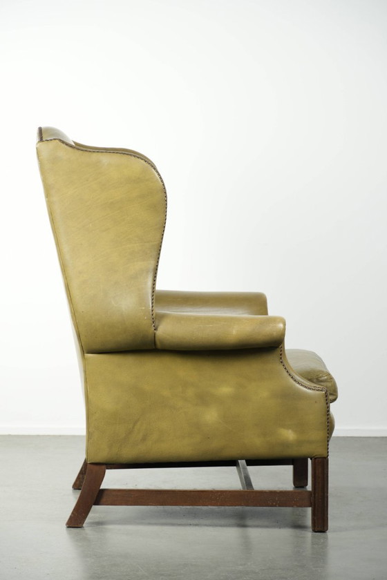 Image 1 of Fauteuil à oreilles ancien et élégant en cuir de vachette vert, de style classique de maison de campagne anglaise.
