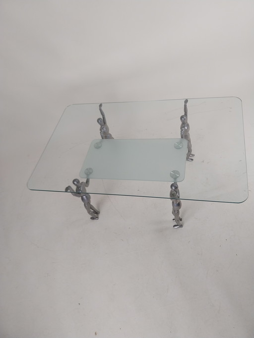 1 x Glas-Couchtisch, getragen von 4 Aluminium-Puppen aus den 1980er Jahren