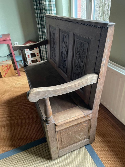 Banc d'église ancien avec sculptures sur bois et espace de rangement