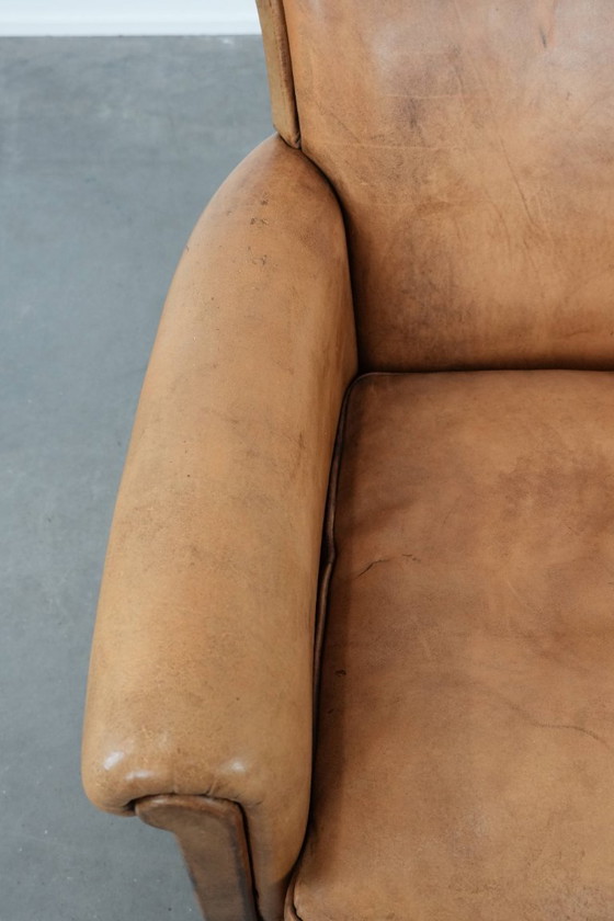 Image 1 of Fauteuil vintage discret en peau de mouton aux pieds gracieux