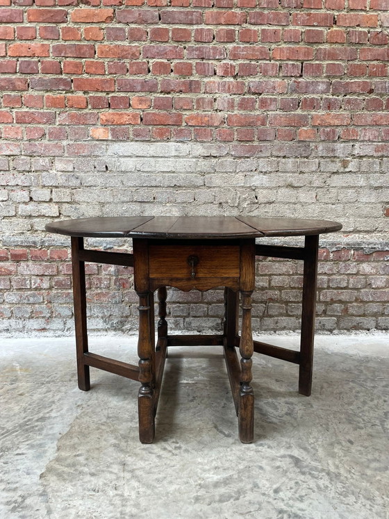 Image 1 of Tavolo antico in rovere con gambe a ribalta e cassetto