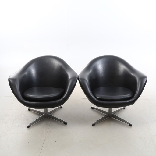 Paire de fauteuils pivotants vintage en similicuir noir avec pieds chromés, datant des années 1980-1990 et en bon état.