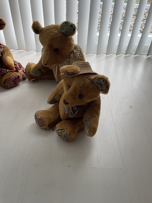 Set di orsetti di peluche vintage, di varie dimensioni e con diversi abiti.