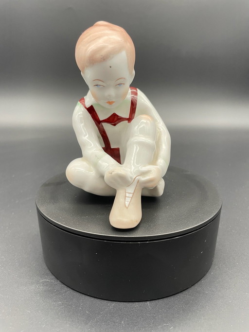 Aquincum Budapest – Sculpture vintage en porcelaine Garçon mettant ses chaussures, Hongrie