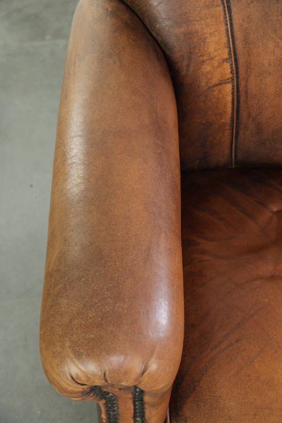 Comoda poltrona in pelle di pecora, dal carattere deciso, rifinita con borchie decorative e una splendida (photo 7 of 13)