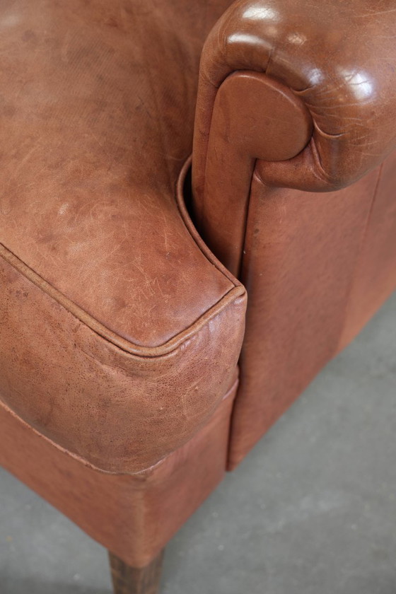 Image 1 of Poltrona a orecchioni color cognac chiaro, rivestita in pelle bovina, dal caratteristico look inglese.