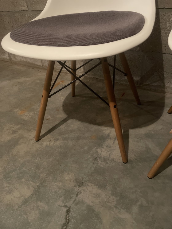 Image 1 of 1 of 2 witte plastic stoelen van Charles Eames met antracietkleurig kussen