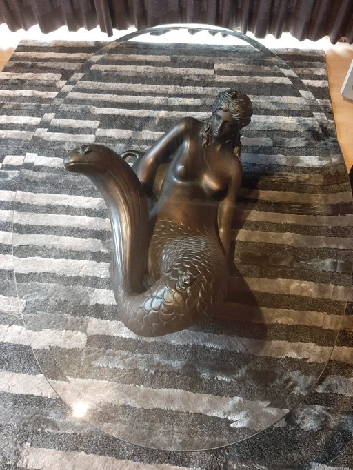 Bronze-colored mermaid coffee table with glass top