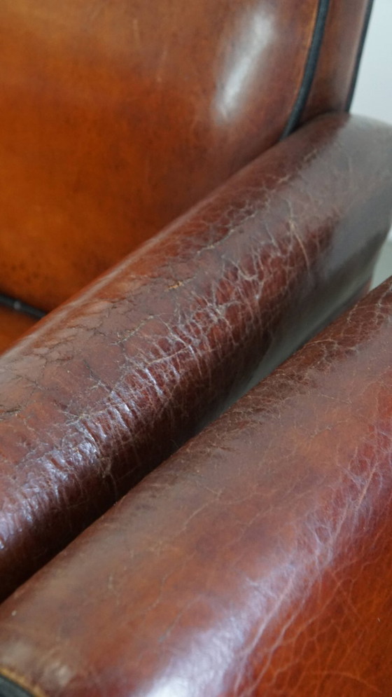 Image 1 of 4 x Vintage schapenleren eetkamerstoel met zwarte biezen op wieltjes