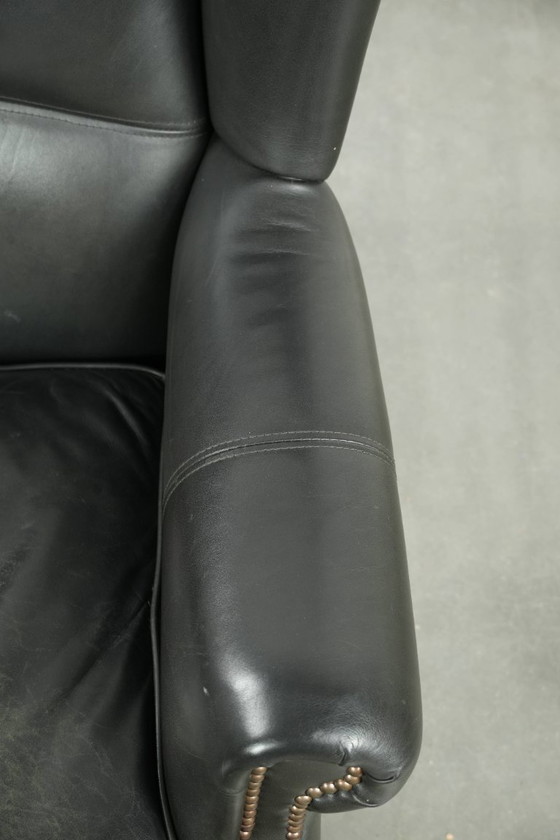 Image 1 of Zwarte rundleren oorfauteuil in een klassiek Engelse stijl