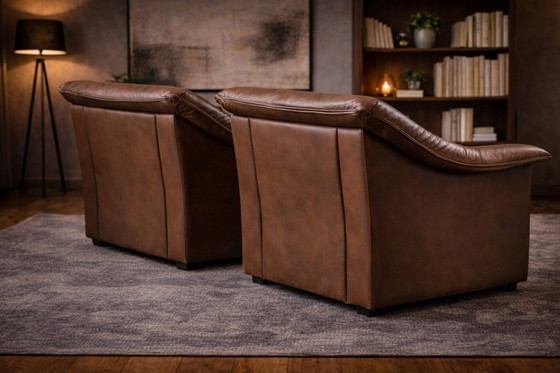 Image 1 of Pair of mid‑century brown leather club armchairs in good condition with small signs of aging and blemishes