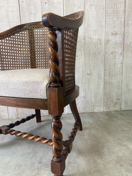 Image 1 of Poltrona antica con intreccio in vimini e decorazioni in legno.