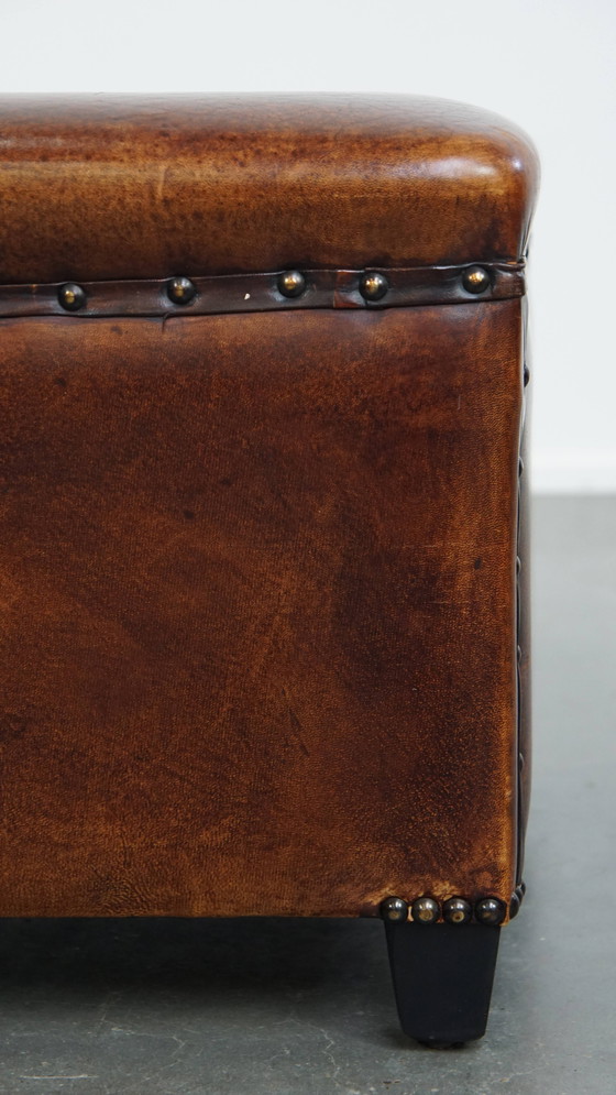 Image 1 of Cognac-kleurige schapenleren hocker met siernagels