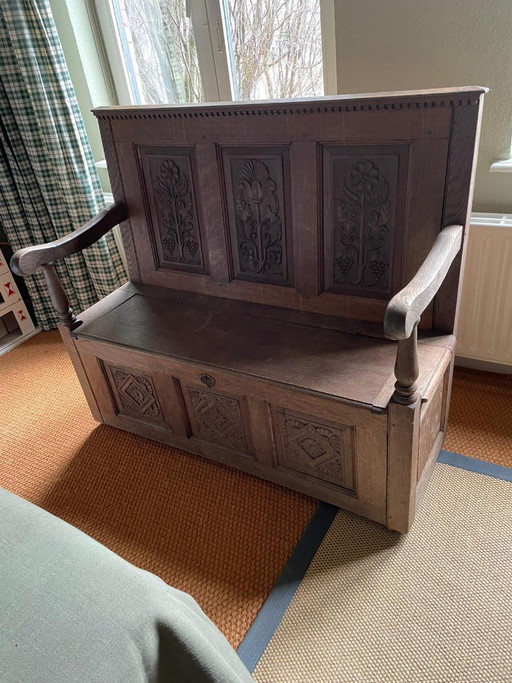 Banc d'église ancien avec sculptures sur bois et espace de rangement