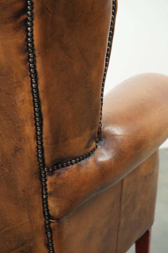 Image 1 of Comfortabele oorfauteuil gemaakt van schapenleer afgewerkt met siernagels en een karaktervolle uitstraling in Engelse stijl