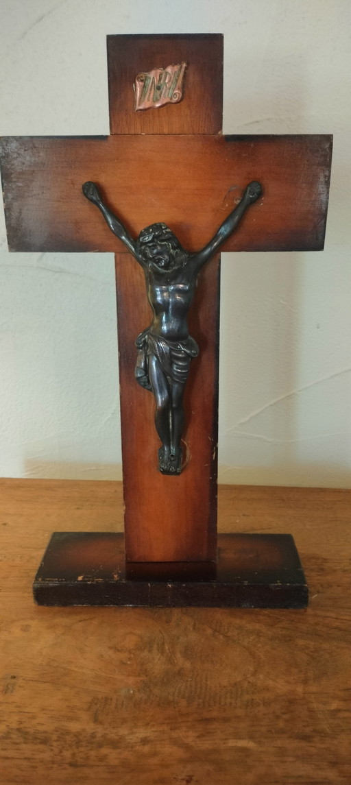 Small copper crucifix on a wooden plank