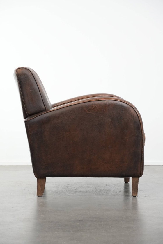 Image 1 of Tijdloze vintage schapenleren design fauteuil in een donkere cognac kleur