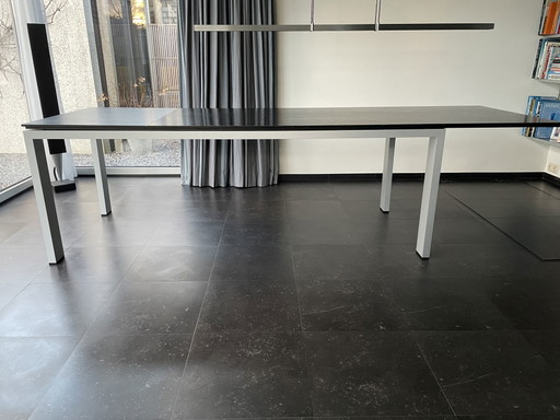 Tavolo allungabile grafico Arco con piano in legno e gambe in alluminio.